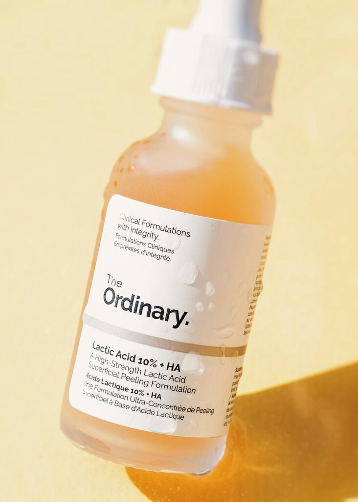 A vertical close-up of a lactic acid serum bottle by The Ordinary, showcasing product details.
